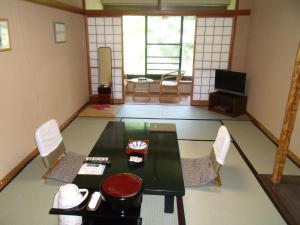Pokój ze stołem, krzesłami i telewizorem w obiekcie Takaragawa Onsen Ousenkaku w mieście Minakami