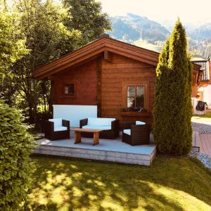 eine Blockhütte mit einem Tisch und Stühlen im Hof in der Unterkunft Dorfchalets Kaprun in Kaprun