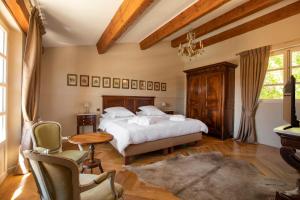 a bedroom with a bed and a table and chairs at Domaine De La Chapelle in Lorgues