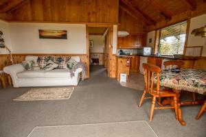 The Cottage Wai Rua في Ruatangata West: غرفة معيشة مع أريكة وطاولة