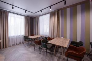 poczekalnia ze stołami, krzesłami i oknami w obiekcie Hotel "Na Kamushkah" w mieście Biełokuricha