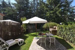 un patio con mesa, sombrilla y sillas en Castellare in Chianti en Gaiole in Chianti