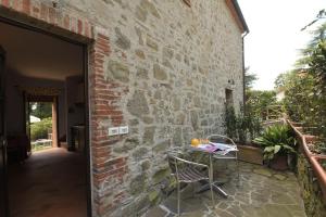een patio met een tafel en een bakstenen muur bij Castellare in Chianti in Gaiole in Chianti