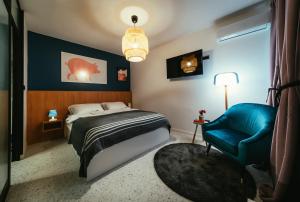 Un dormitorio con una cama y una silla azul. en EM Kastelo Zadar, en Zadar