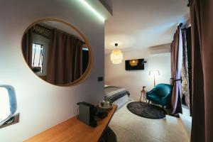 Habitación con espejo, cama y silla en EM Kastelo Zadar, en Zadar