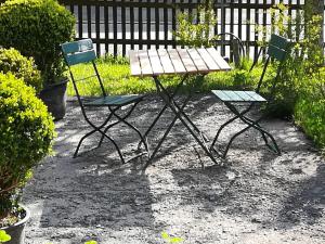 - une table de pique-nique et deux chaises dans la cour dans l'établissement Ferienwohnung Hasenfratz, à Löffingen
