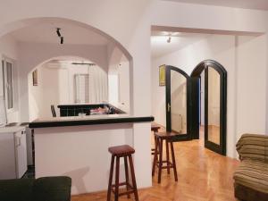 a kitchen and living room with a counter and stools at Hostel Holiday Cetinje in Cetinje