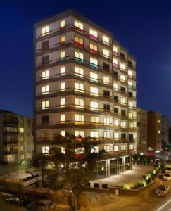 a tall building with many windows at night at Armoni Residence Istanbul in Istanbul