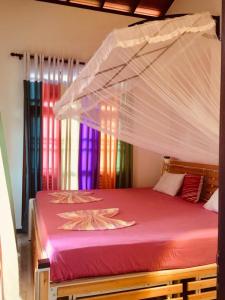 a bedroom with a red bed with a canopy at Amaya Gate in Matara