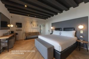 a bedroom with a large bed and a desk at MaisonMe Boutique Hotel in Bardolino