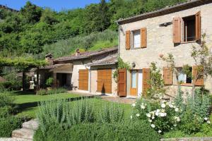 a stone house with a garden in front of it at Villa Porsenna in Chiusi
