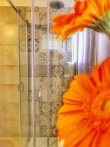 une douche avec une porte en verre et une fleur dans l'établissement PETRAMARE, à Cursi