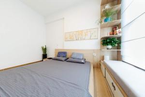 a small bedroom with a bed with blue pillows on it at Ecopark QV Homestay JAPAN in HÆ°ng YÃªn +9 photos
