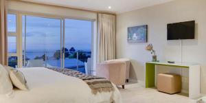 a bedroom with a large bed and a large window at Amber Place in Cape Town