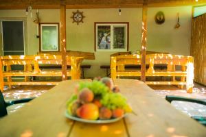 ein Teller mit Obst auf einem Holztisch in der Unterkunft Casa Boby in Murighiol
