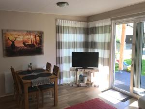 una sala da pranzo con un tavolo e una TV di Allgäu-Chalet a Buchloe