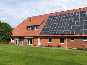 ein Backsteinhaus mit Sonnenkollektoren auf dem Dach in der Unterkunft Modernes Apartment in ruhiger Lage, 70qm, 4 Personen in Brietlingen