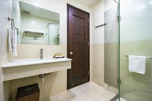 a bathroom with a sink and a glass shower at Emerald Serviced Apartment in Ho Chi Minh City