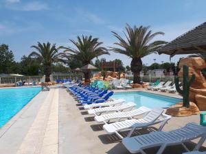 a pool with chaise lounge chairs and a resort at Vias Plage Camping Salisses in Vias