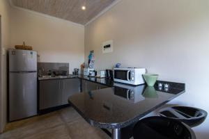 a kitchen with a counter with a microwave and a refrigerator at Nature's Cottage in Kenton on Sea