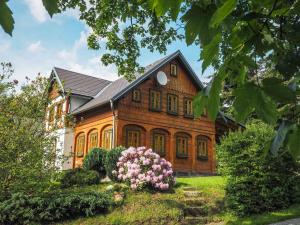 duży drewniany dom z kwiatami przed nim w obiekcie Chalupa Lužické hory w mieście Dolní Světlá