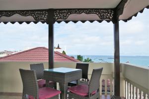 a patio area with chairs, tables and umbrellas at Best Western Plus Zanzibar in Zanzibar City