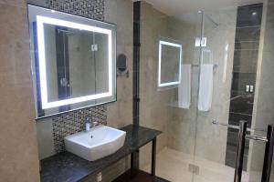 a bathroom with a sink, toilet and mirror at Best Western Plus Zanzibar in Zanzibar City