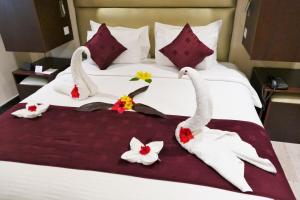 a bed with a white bedspread and a red and white bedspread at Best Western Plus Zanzibar in Zanzibar City