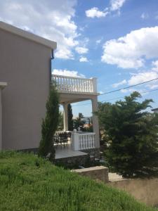 a white house with a porch with a table and chairs at Apartment Cesarica in Cesarica