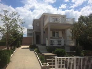 a house with a white fence in front of it at Apartment Cesarica in Cesarica
