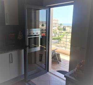 Una cocina con una puerta de cristal que da a un balcón. en Casa Marques, en Lagos