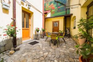 a patio with a table and chairs in front of a building at Apartament Simon Brasov in Braşov