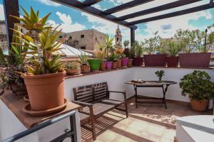 a patio with potted plants and a table and bench at Rooms 19 B&B in Palermo