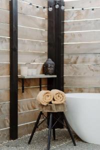 uno sgabello con asciugamani accanto a una vasca da bagno di Three Streams Raglan Retreat a Raglan
