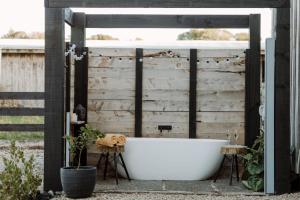 una vasca da bagno situata di fronte a una parete in legno di Three Streams Raglan Retreat a Raglan