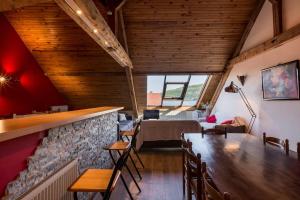 a dining room with a table and a stone wall at Duplex au Bord du Lac in Duingt