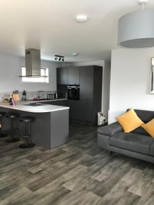 a living room with a couch and a kitchen at Apt 2, Frasers Close in Kirkwall
