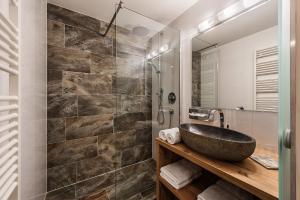 ein Badezimmer mit einem Steinwaschbecken und einer Dusche in der Unterkunft Natur Residenz Anger Alm - Adults only in Sankt Leonhard im Pitztal
