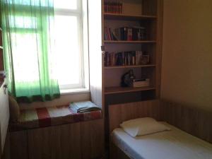 a small bedroom with a window and a bed and a book shelf at Old Tbilisi Flavor for You in Tbilisi City