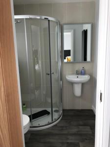 uma casa de banho com uma cabina de duche em vidro e um lavatório. em Apt 2, Frasers Close em Kirkwall