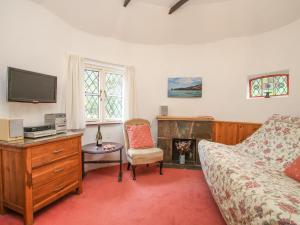a bedroom with a bed and a desk and a tv at Millstream in Tintagel
