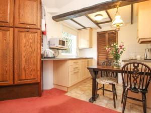 a kitchen with a table and chairs and a microwave at Millstream in Tintagel