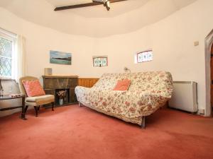 a bedroom with a bed and a chair and a fireplace at Millstream in Tintagel