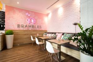 a restaurant with tables and chairs and a pink wall at Citadines Metro Central Dubai in Dubai