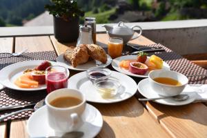 a table with plates of food and cups of coffee at The Alpina Mountain Resort in Tschiertschen