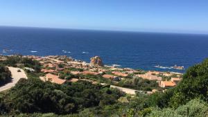 a small town on a hill next to the ocean at Villino Saccu in Costa Paradiso +3 photos