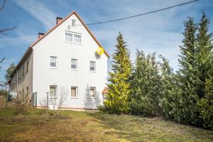 a white house with trees in front of it at Ferienwohnung am Bauernhof in Oederan
