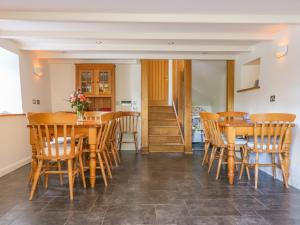 a dining room with wooden tables and chairs at Carne Mill in Helston