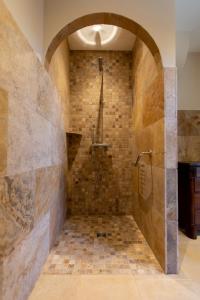 a bathroom with a shower in a brick wall at Domaine De La Chapelle in Lorgues