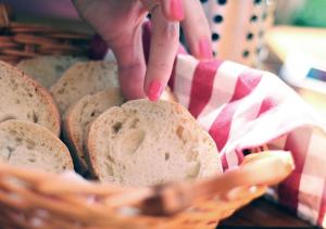 eine Person, die ein Stück Brot in einem Korb hält in der Unterkunft Hôtel de Torgon in Vionnaz